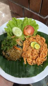 a plate of food with rice and vegetables on a banana leaf at Bali Chy Healing House in Dalung