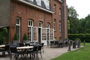 un groupe de tables et de chaises devant un bâtiment dans l'établissement Klooster Nieuwkerk Goirle, à Goirle