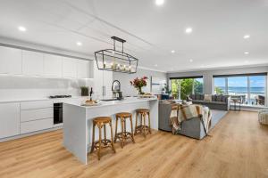 a kitchen with a large island with bar stools at The Jetty Huskisson in Huskisson