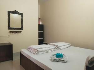 a bedroom with two beds with towels and a mirror at Udita Homestay Prayas in Shānti Niketan