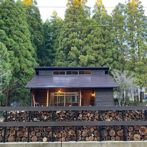une cabane en rondins dotée d'un tas de bois de chauffage dans l'établissement Mokufusya private camp&cottage - Vacation STAY 97725v, à Komatsu