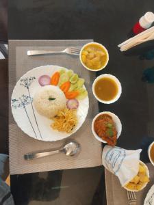 a table with a plate of food and bowls of food at Udita Homestay Prayas in Shānti Niketan