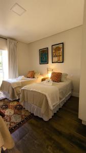a hotel room with two beds and a window at Aconchego da Serra com Hidro Vista e Conforto Total in Gonçalves +20 photos