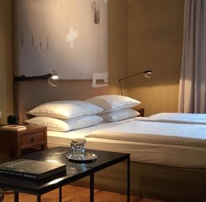 ein Hotelzimmer mit 2 Betten und einem Tisch in der Unterkunft Strandhotel Margaretha in St. Wolfgang