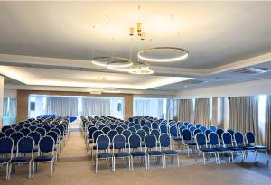 a room with rows of chairs and chandeliers at Hôtel Ivotel Abidjan in Abidjan
