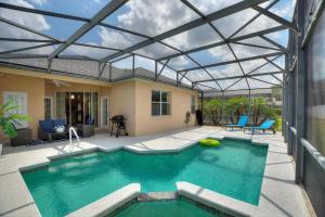 a swimming pool with a glass roof over a house at Chic 4BR,Heated Pool,Jacuzzi & Dining Oasis near Disney & Legoland in Haines City