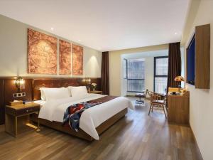 ein Hotelzimmer mit großem Bett und Schreibtisch in der Unterkunft James Joyce Coffetel Zhengzhou CBD Exhibition Center Provincial People's Hospital in Zhengzhou + 277 Fotos