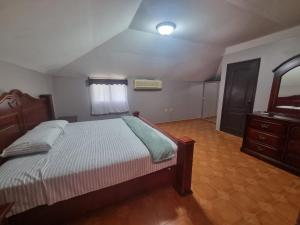 a bedroom with a bed and a dresser and a mirror at El Eden de la Familia in Choluteca +10 photos