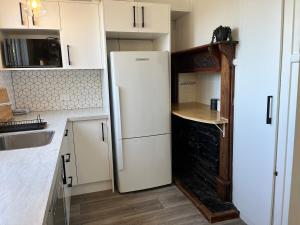 a kitchen with a white refrigerator and a sink at Pretty Villa Close to St Clair Beach private parking in Dunedin