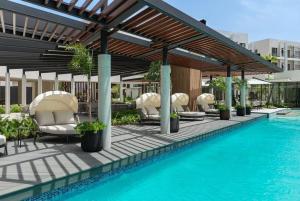 a patio with chairs and a swimming pool at Vista Cana punta cana beach Paradise Pool & Lake golf Condo in Punta Cana