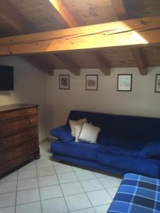 een woonkamer met een blauwe bank en een tv bij Casa Zen in Valfurva