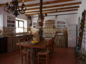 a kitchen with a wooden table and a refrigerator at El molino del abuelo in Montecorto