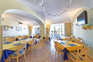 un ristorante con tavoli e sedie in una stanza di Hotel Punta Imperatore a Ischia