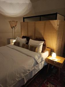 a bedroom with a bed and a table with a lamp at NATUR - Krabi Campsite Glamping & Camping in Krabi town