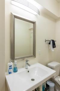 ein weißes Badezimmer mit Waschbecken und Spiegel in der Unterkunft Elegant & Charming 2BR Apartment in Glendale + 51 Fotos