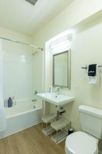 ein weißes Badezimmer mit Waschbecken und Toilette in der Unterkunft Elegant & Charming 2BR Apartment in Glendale