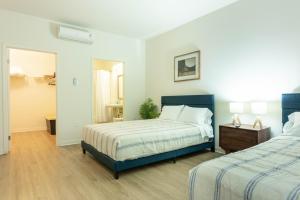 ein Schlafzimmer mit 2 Betten und einem Tisch mit einem Nachttisch in der Unterkunft Elegant & Charming 2BR Apartment in Glendale