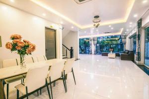een eetkamer met een tafel en stoelen bij Villa NT119 FLC Sầm Sơn in Sầm Sơn +12 foto's
