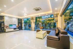 een grote woonkamer met een bank en een tv bij Villa NT119 FLC Sầm Sơn in Sầm Sơn