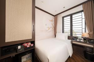 ein Schlafzimmer mit einem weißen Bett und einem Fenster in der Unterkunft Legend Smart Hotel in Phú Thú