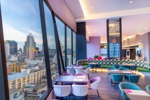a restaurant with a view of a city at Queensland Hotel Bangkok in Bangkok