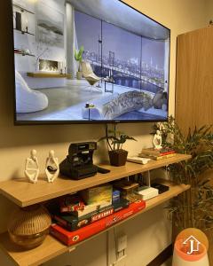 a flat screen tv sitting on a shelf with books at Studio With Balcony Near Beaches in Mactan in Lapu Lapu City