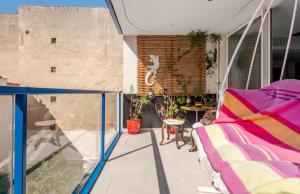 a room with a balcony with a bed and a table at Casa de Marseille in Marseille