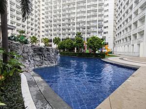 马尼拉La Vie Riche Holiday Homes - Cozy 1BR Apartment near MOA的大楼前的游泳池