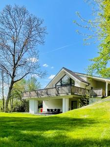 ein weißes Haus mit einer Terrasse auf einem Rasen in der Unterkunft Riverside Avrig in Avrig