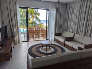 a living room with a couch and a table at ReefScape Beachfront Residence in Trou aux Biches