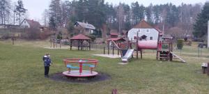 a child standing in a park with a playground at Apartmán Hortenzie in Mařenice