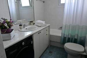 a bathroom with a sink and a toilet and a tub at Magdalena Cozy Apartment in Sparta +37 photos