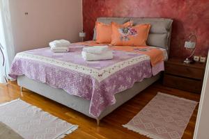 a bedroom with a purple bed with towels on it at Magdalena Cozy Apartment in Sparti