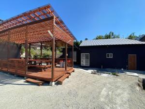 un padiglione di legno in un cortile accanto a un edificio di 時間を忘れる貸別荘サウスブルー a Hatsukaichi