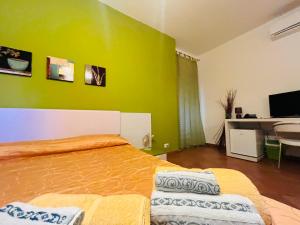a bedroom with a green wall and a bed at Ciuscia in Calatabiano