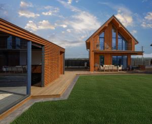 a modern house with a deck and a lawn at Widokownia Bukowinki 2 in Chmielno +20 photos