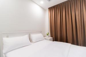a bedroom with a white bed and brown curtains at Sunrise Stay 202 Comfy Modern Room in Hulhumale by the Beach in Hulhumale