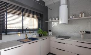 a kitchen with white cabinets and a sink and a window at Widokownia Bukowinki 2 in Chmielno