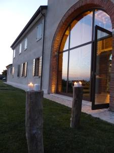a building with two stone pillars with candles in front of it at Corte Motte in Pegognaga