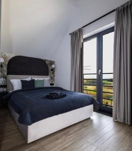 a bedroom with a large bed and a large window at Widokownia Bukowinki 2 in Chmielno