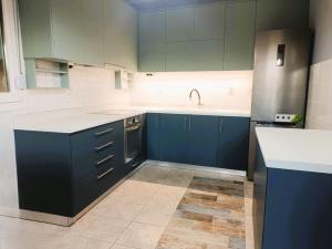 a kitchen with blue cabinets and a sink at VILLA ARHONTIKO in Asprovalta