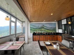 a restaurant with tables and chairs and a painting on the wall at Ghasso Residency in Gangtok