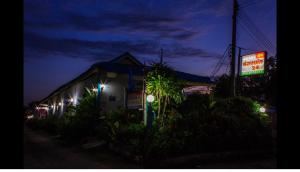 a building with street lights and a sign at night at Jidapha Rooms in Khlong Thom