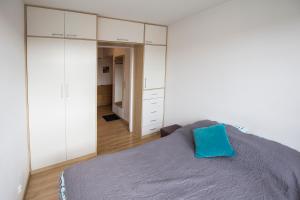 ソポトにあるApartament 22のベッドルーム1室(白いキャビネット、青い枕付)