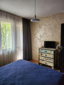 a bedroom with a bed and a dresser and a window at Апартамент 8 in Varna City