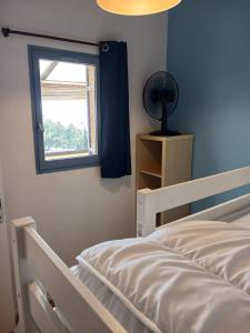 a bedroom with a bed and a window and a fan at Le Sun Piscine Tennis parking Vue mer wi-fi climatisation in Fleury +18 photos