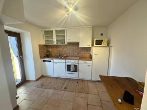 a kitchen with white cabinets and a white refrigerator at appartement Valentine au coeur des 4 Vallées in Conthey +6 photos