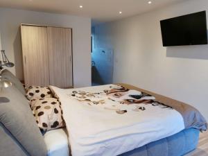 a bedroom with a bed with a cow blanket on it at Ranch du pont urgin in Planrupt