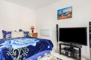 ピエールフィット・シュル・セーヌにあるStudio Appartment with Office wifi parking balconyのベッドと薄型テレビのある寝室