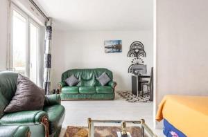 ピエールフィット・シュル・セーヌにあるStudio Appartment with Office wifi parking balconyの緑のソファとテーブルのあるリビングルーム +1枚の写真